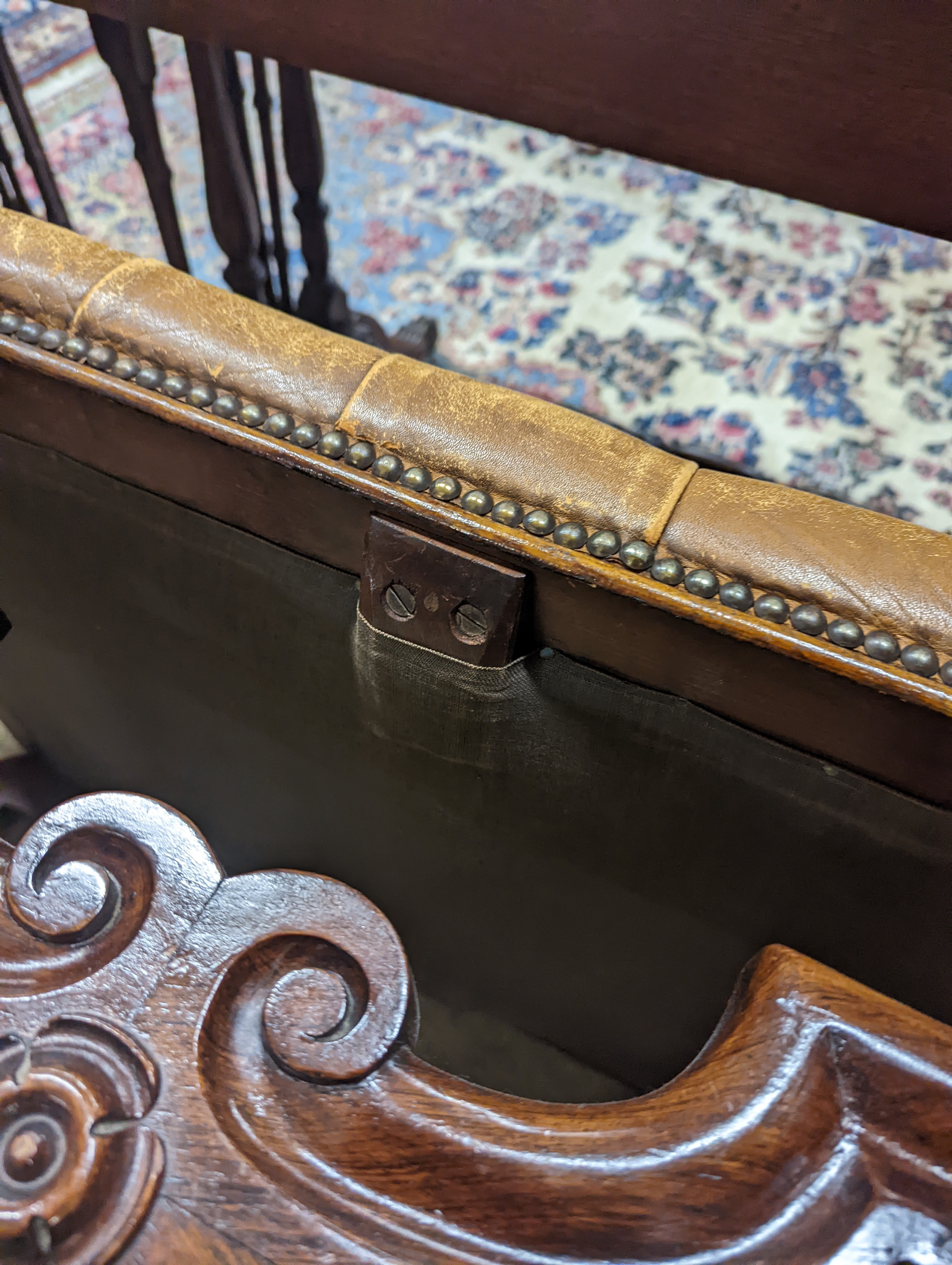 A Victorian carved X-framed rosewood footstool, upholstered in a buttoned brown leather, width 90cm depth 57cm height 42cm